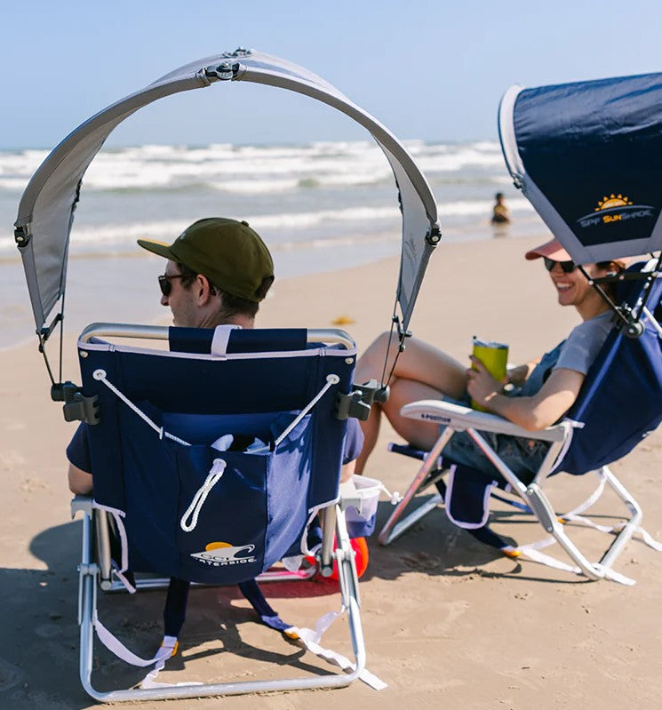 A couple of people using beach chairs that they rented from Northern Explorer Supply. Each beach chair is made by GCI and is equipped with a canopy accessory. These chairs are set up on Long Sands Beach.