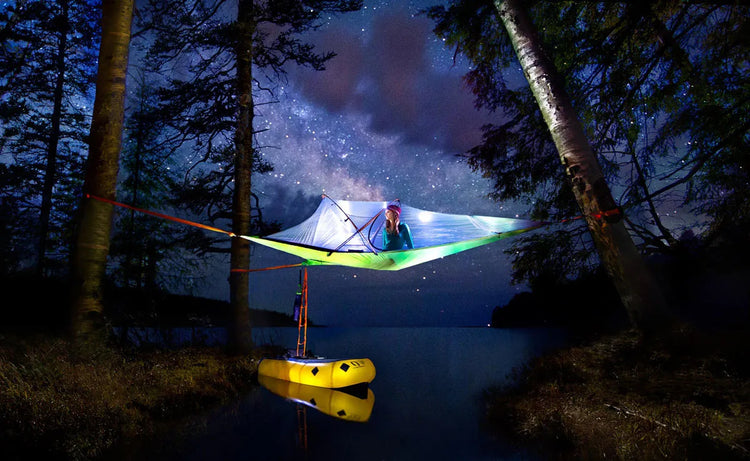 Tentsile tree tent suspended between trees at a campsite.